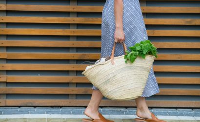 woman is holding straw back for shopping with products without plastic packaging. minimalistic concept